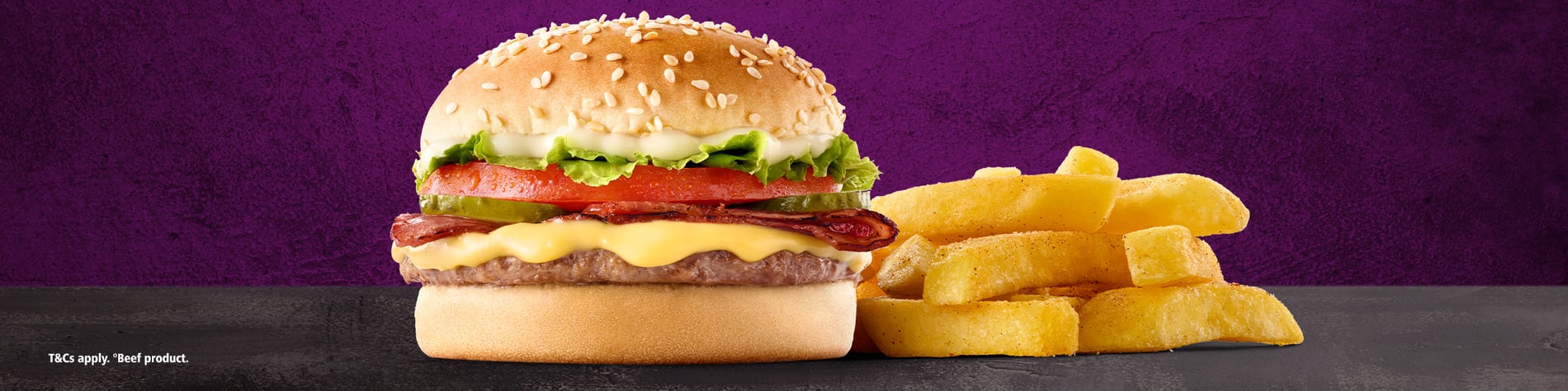 An image of the NEW Phanda® Cheesy Bacon Burger with a side of chips, both placed on a grey surface with a purple background.