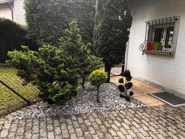 Thury Paysagiste & Services – Aménagement paysager avec pose de galets décoratifs et taille de végétaux à Froideville dans le canton de Vaud. Création d’un espace extérieur soigné et esthétique nécessitant peu d’entretien.