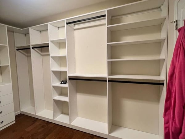 A white custom closet with space-saving dividers and shelves.