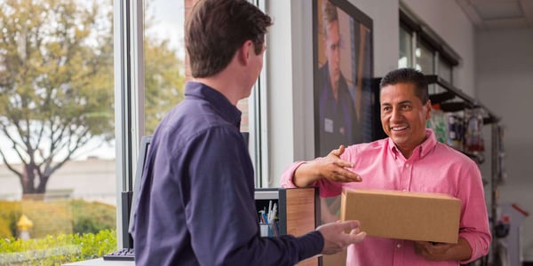 customer and FedEx employee interacting with package