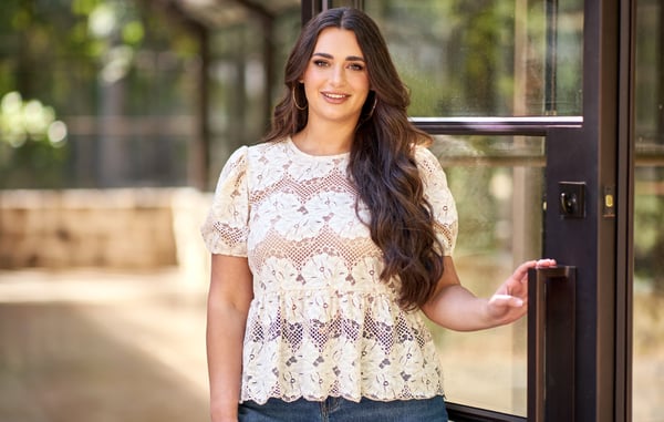 Woman is wearing a plus size lace peplum top.