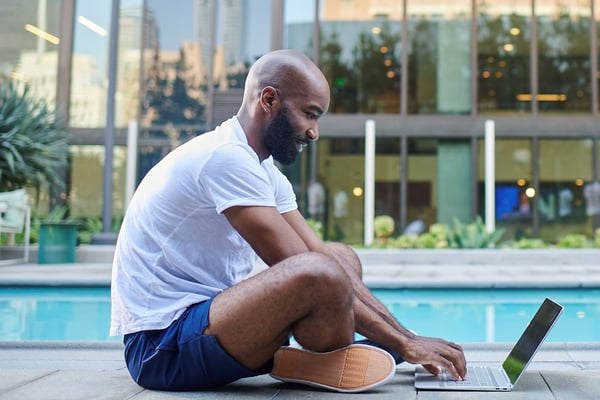 Man using free WiFi next to a swimming pool