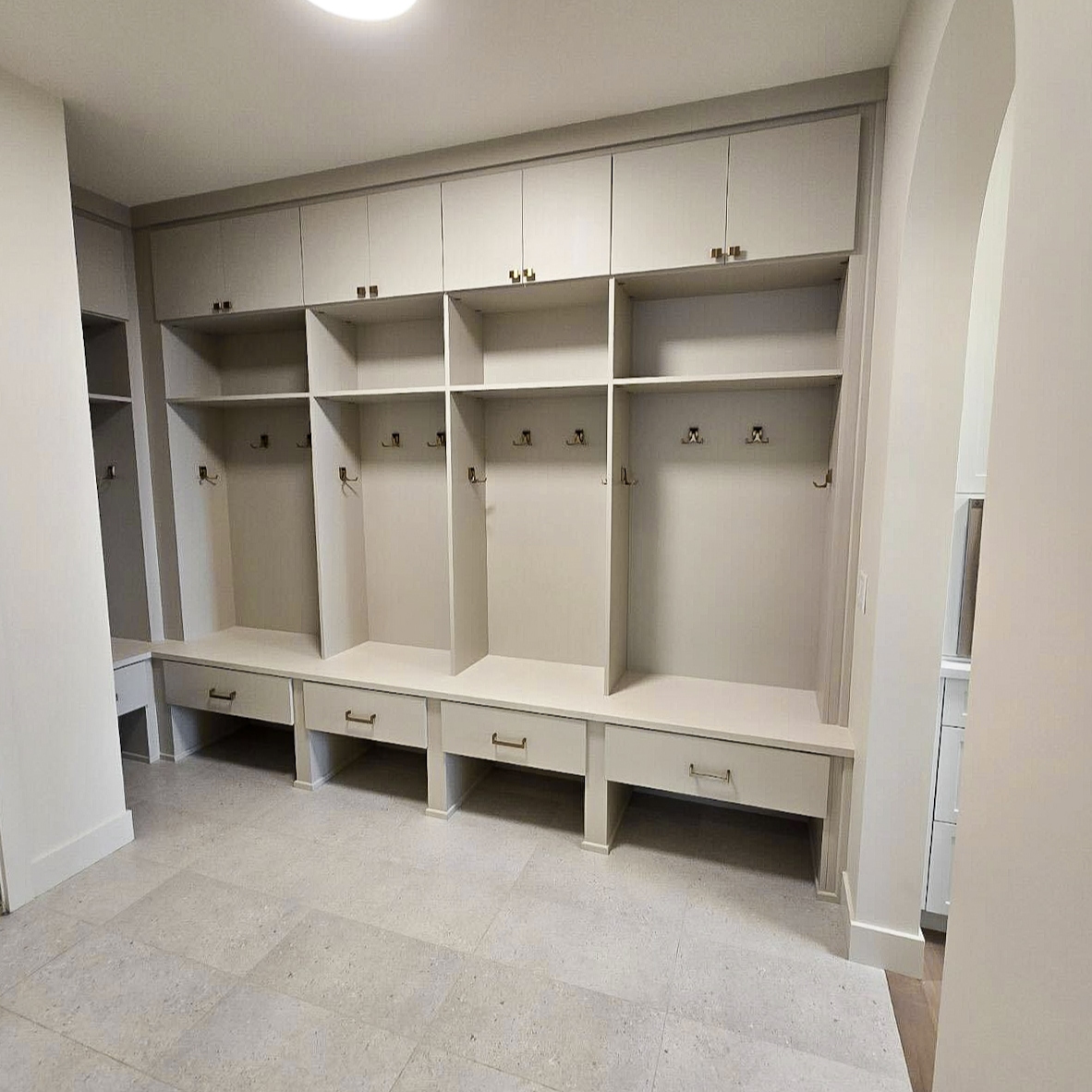 Mudroom with upper cabinetry, open shelving, open locker style cubbies with hooks for coats, drawers.