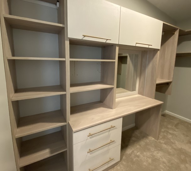 Large walk-in closet with open shelves in two-tone light finishes.