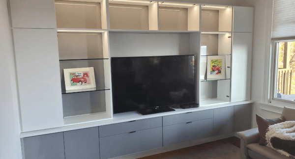 Entertainment center with lighted shelving and drawers.