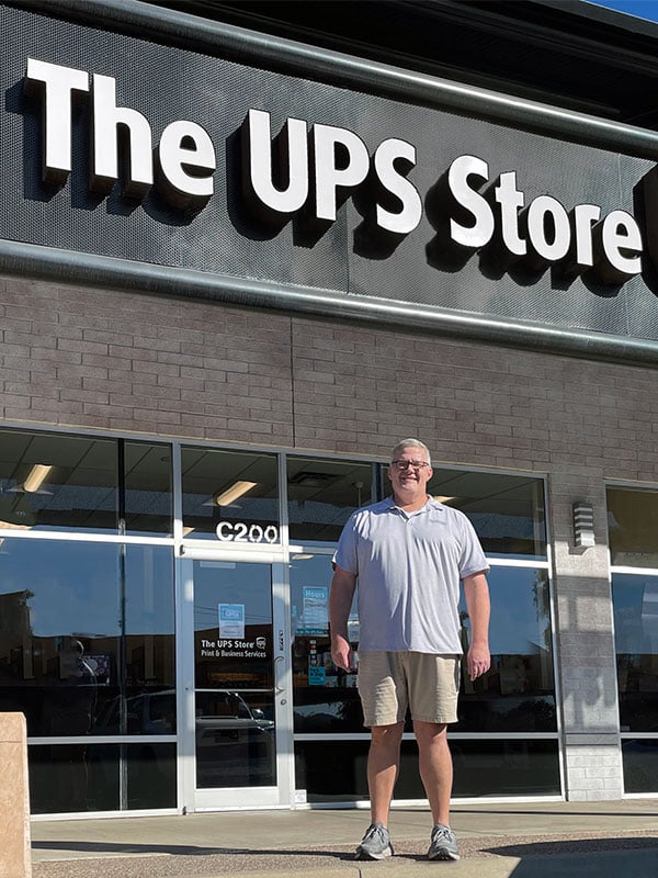 The UPS Store owner standing outside, in front of his store.