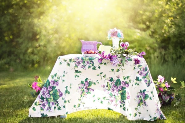 table with tablecloth, flowers, and food