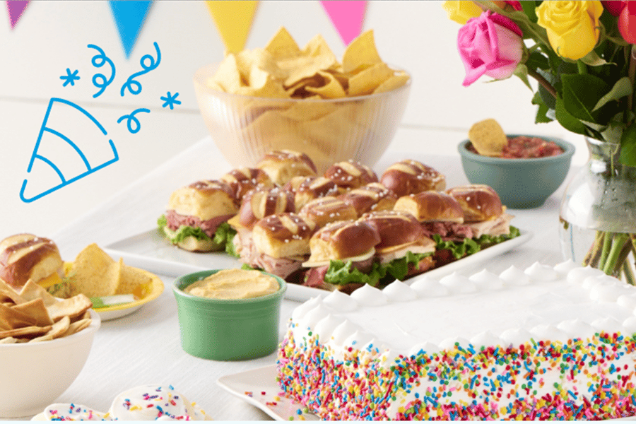 party food and a custom birthday cake with sprinkles and white frosting