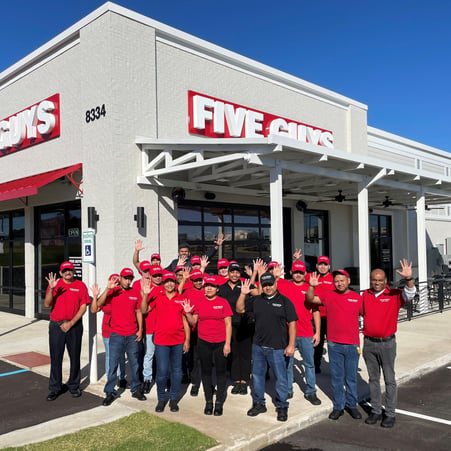 Employees gather for a photograph outside the entrance to the Five Guys restaurant at 8334 Highway 72 West in Madison, Alabama.