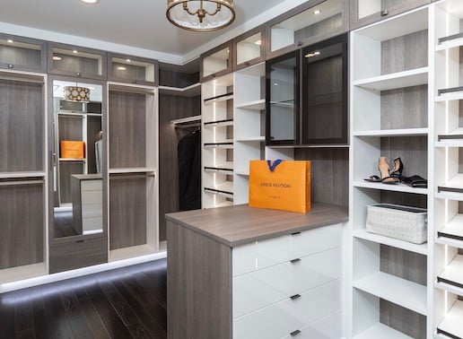 Master walk-in with peninsula island and closet lighting.