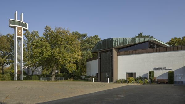 Ein modernes Kirchengebäude mit Glockenturm und Kirchenuhr.
