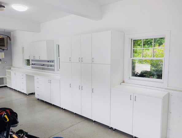 White garage storage with upper and lower cabinets by California Closets Norwalk, Connecticut.