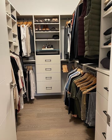 Walk-In closet design an off white finish with black hardware. There is a combination of double hang, long hang, shelving and drawers.