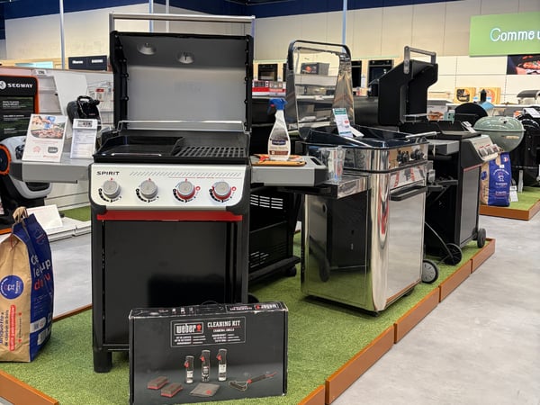 Vue du rayon barbecue avec les produits disposés en magasin.