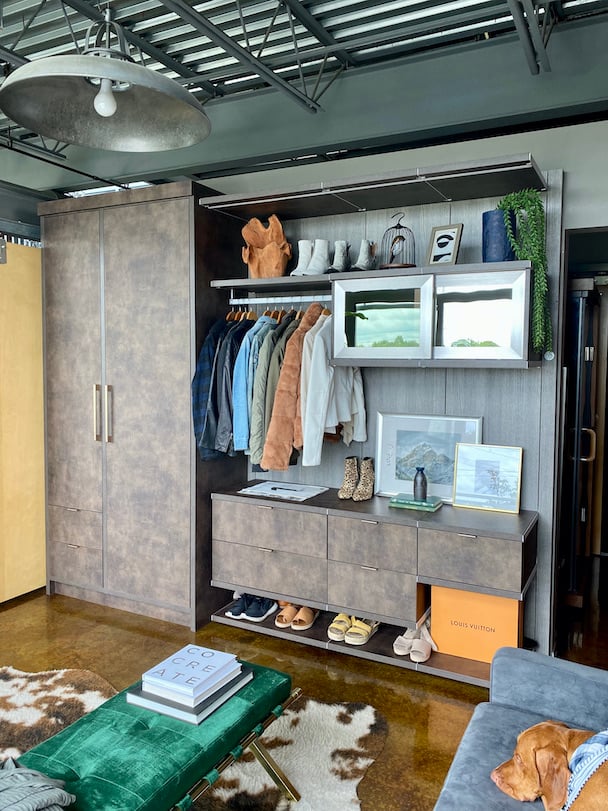 Contemporary loft wardrobe with fur accent rug and green bench.