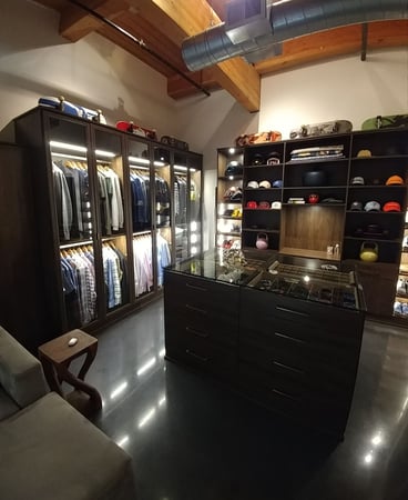 Black sleek closet with center island and hanging space.
