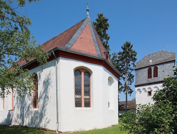 Zu sehen ist die Kirche Horrweiler, die umgeben ist von einer Wiese und Bäumen.