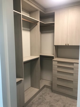 Walk-in closet with double hang, drawers, and closed cabinetry.