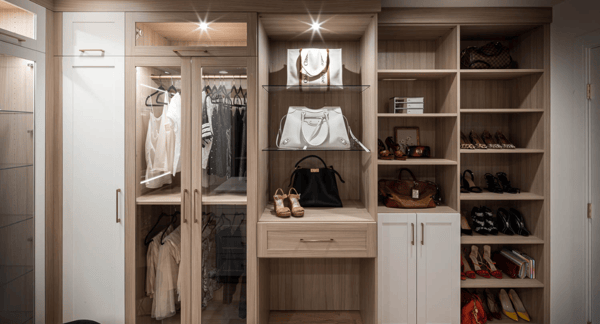 Img 9 California Closets Westchester County New York Two Toned White and Beige Large Walk-in Luxury Closet with Glass Shelving, Glass Doors, Lighting, and a Custom Center Island with Custom Jewelry Drawers