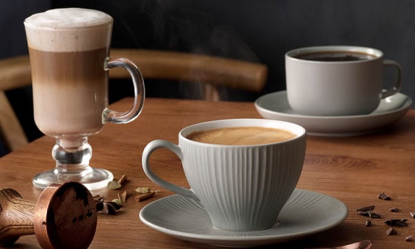 A variety of coffees and hot drinks on a wooden table