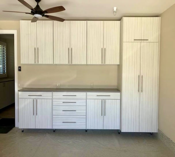 Custom garage storage with light wood cabinets