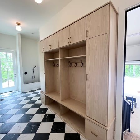 Keep those dirty shoes at the door! Natural finish mudroom with gold hardware and slab doors and drawers.