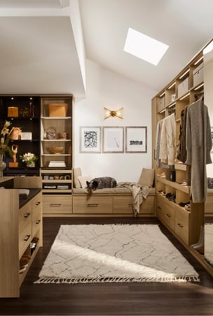 Custom Walk-In Closet with Built-In Bench Seating Drawer Storage Open Shelving Hanging Sections Light Wood Cabinetry Skylight Lighting by California Closets South Palm Beach Florida