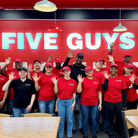 Crew members pose for a photograph inside the dining room ahead of the grand opening of the Five Guys restaurant at 601 Harry L Drive in Johnson City, New York.