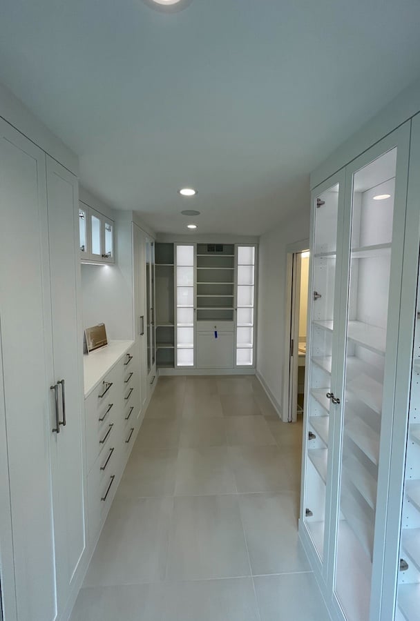 custom luxe walk in closet with drawers, hanging space, and integrated lighting