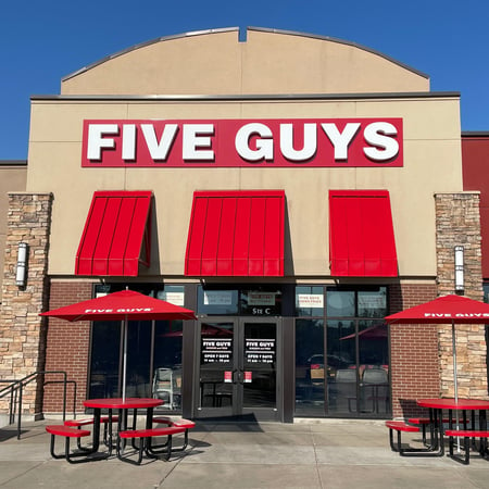 Exterior photograph of the entrance to the Five Guys restaurant at 2065 North Harris Boulevard in Layton, Utah.