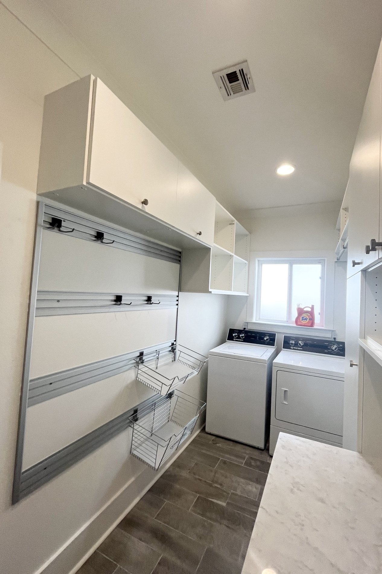 Custom cabinets for laundry room with hamper baskets  by California Closets Baton Rouge, Louisiana.