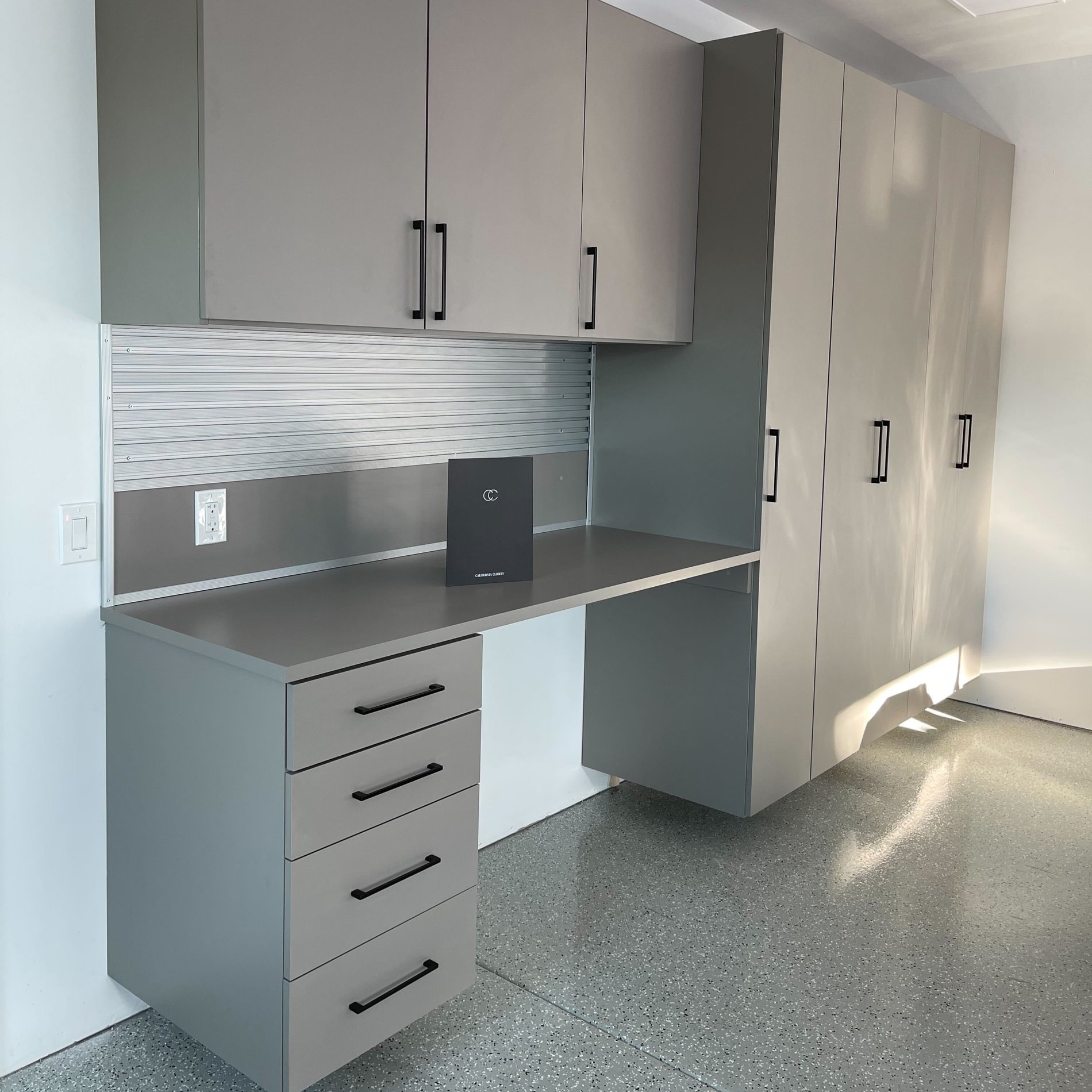 Grey garage workspace storage with cabinets and drawers