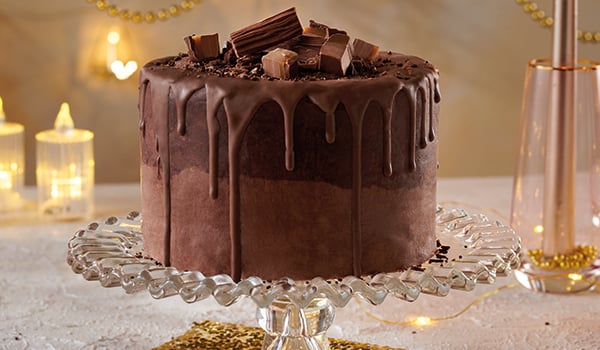 Death by Chocolate NiceCream Cake on a glass cake tray with a beige background.
