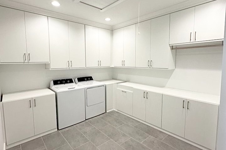 Cabinets for laundry room with hidden hamper baskets California Closets Pensacola & Panama City, Florida