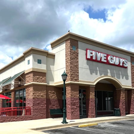 Exterior photograph of the entrance to the Five Guys restaurant at 1757 East West Connector in Austell, Georgia.