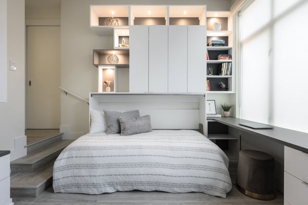A front view of a pulled out murphy bed with built in storage, lighting and an intergrated desk