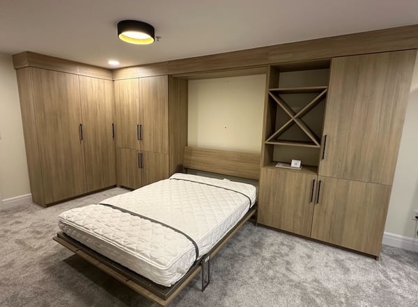 Murphy bed with shelves, wine X and cabinets in light wood by California Closets Greater Detroit, Michigan.