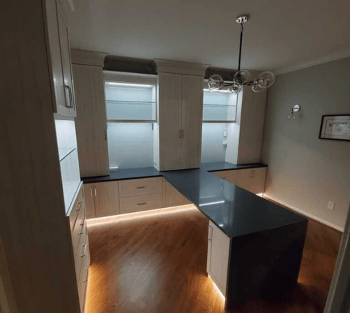 Craft room with shelving, cabinets, drawers, and a counter.