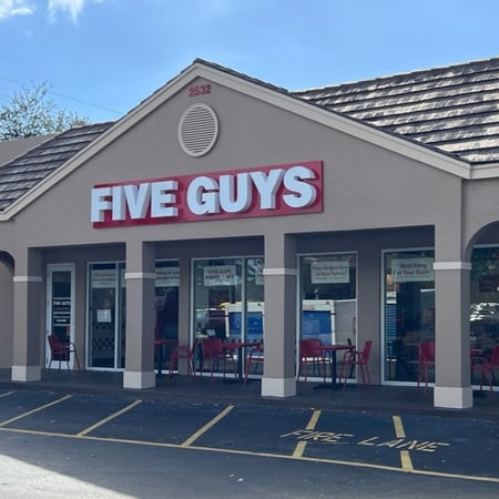 An exterior photograph of the entrance to the Five Guys restaurant at 2532 W. Indiantown Road in Jupiter, Florida.