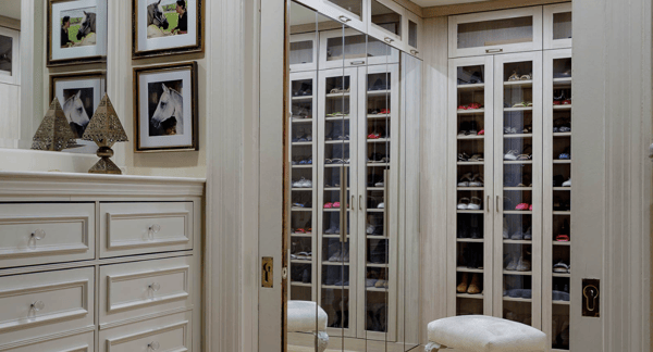 natural wood walk-in closet with mirrored doors, glass doors for floor to ceiling shoe storage to look like boutique closet Tribeca New York
