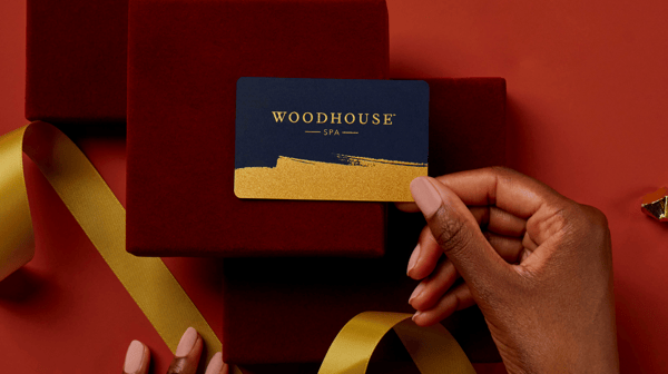 Someone gifting their friend or family member a Woodhouse Spa gift card.