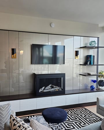 Entertainment space with fireplace, floating shelves, hidden storage by California Closets Toledo, Ohio.