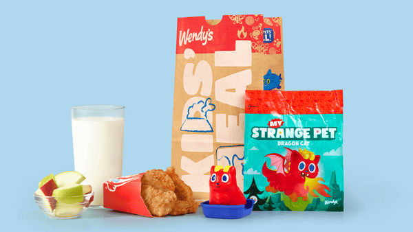 Wendy’s Kids Meal featuring chicken nuggets, apple slices, milk, and a red My Strange Pet dragon cat toy.