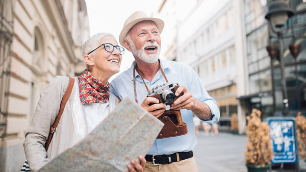 A woman holding a map and a man holding a camera