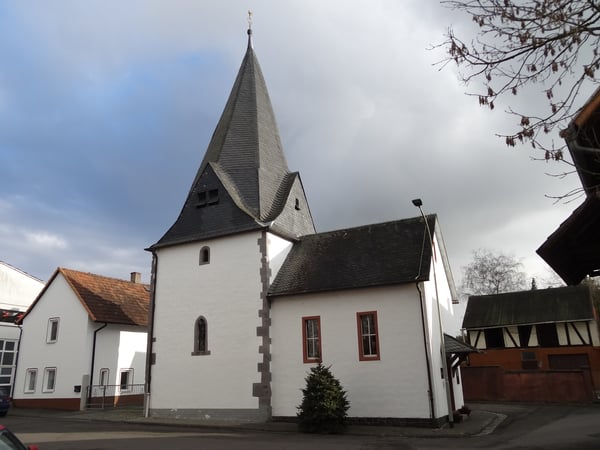Der frühgotische Chorturm wurde in der zweiten Hälfte des 13. Jahrhunderts errichtet. Der steinerne Neubau des Kirchenschiffs von 1962 ersetzt eine Fachwerkkirche aus dem 17. Jahrhundert. Die kleine Kirche mit dem wuchtigen Turm ist ortsbildprägend und hessisches Kulturdenkmal. Die Kirche ist am östlichen Ortsrand des alten Dorfkerns in nordöstlicher Richtung errichtet. Der wuchtige Chorturm aus Bruchsteinmauerwerk mit Eckquaderung aus Lungstein weist einen quadratischen Grundriss von 4,30 × 4,30 Meter auf.