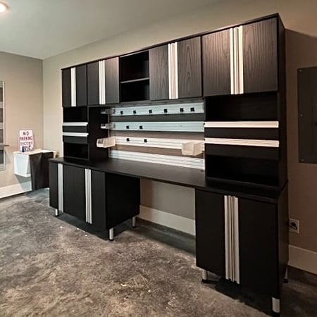 Black and silver garage storage cabinets with a work bench by California Closets Baldwin County & Mobile, Alabama.